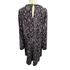 A long-sleeve tunic dress with an intricate multicolor paisley and floral pattern on a black base, displayed on a mannequin torso against a white background.