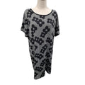 A black and white patterned knit tunic top with a scoop neckline and short sleeves, displayed on a mannequin torso against a white background.