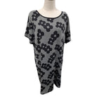 A black and white patterned knit tunic top with a scoop neckline and short sleeves, displayed on a mannequin torso against a white background.