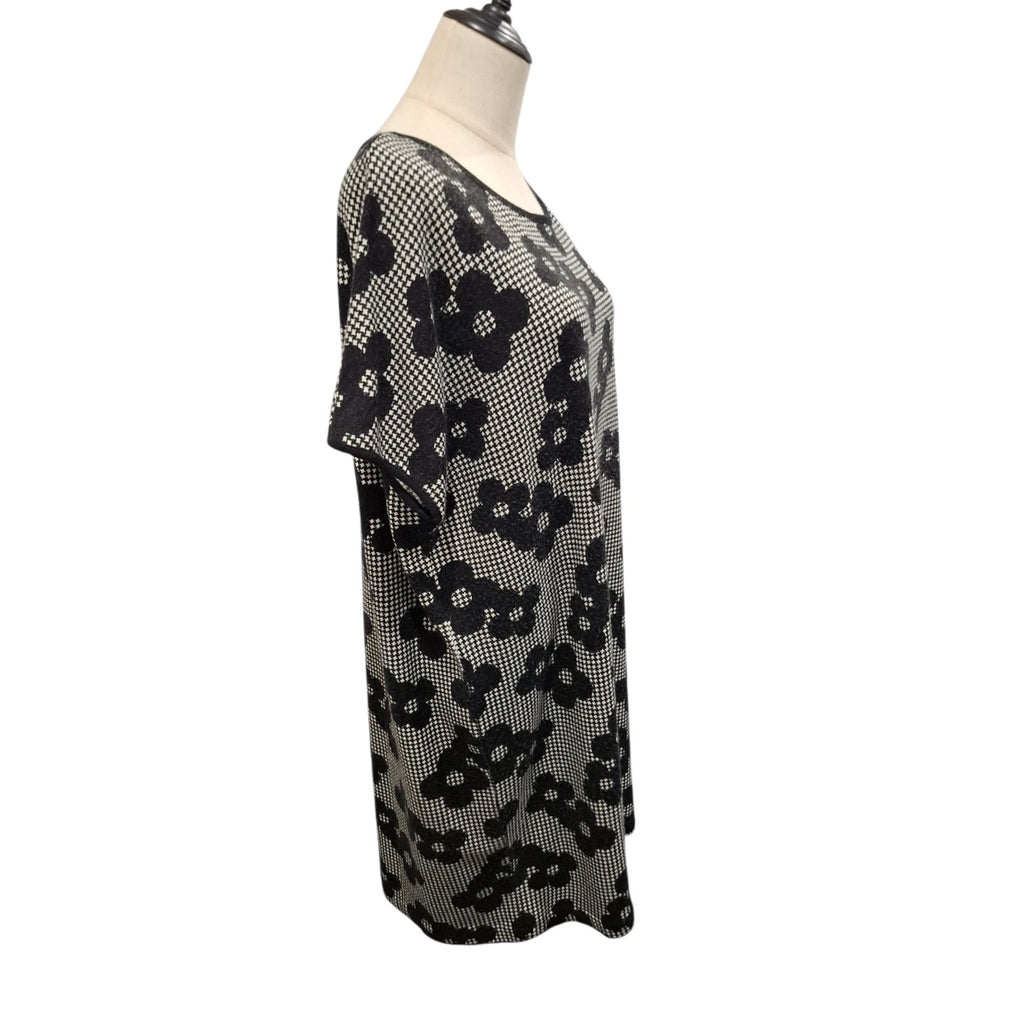 A short-sleeve knit top with a black and white floral pattern, displayed on a mannequin torso against a plain white background.