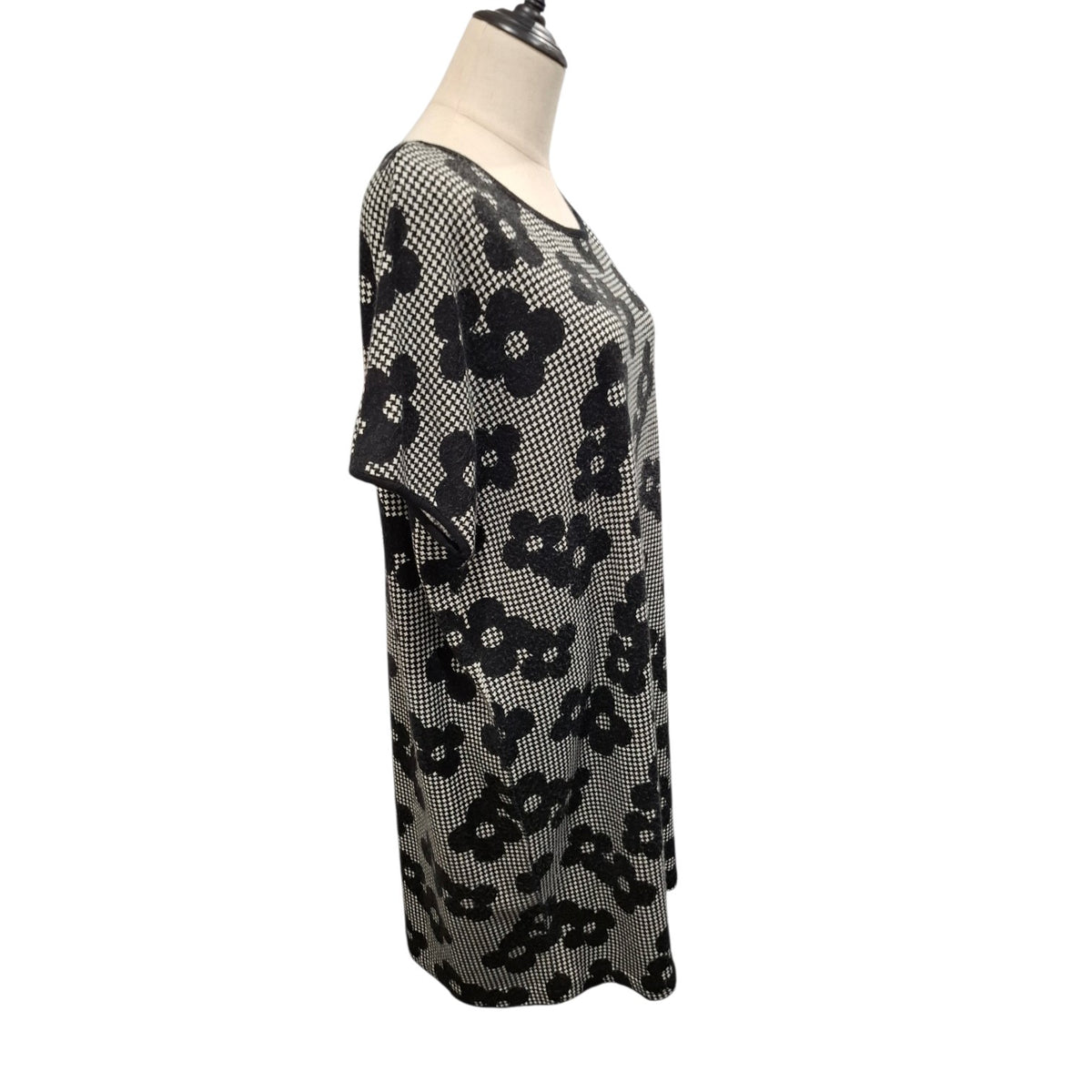 A short-sleeve knit top with a black and white floral pattern, displayed on a mannequin torso against a plain white background.