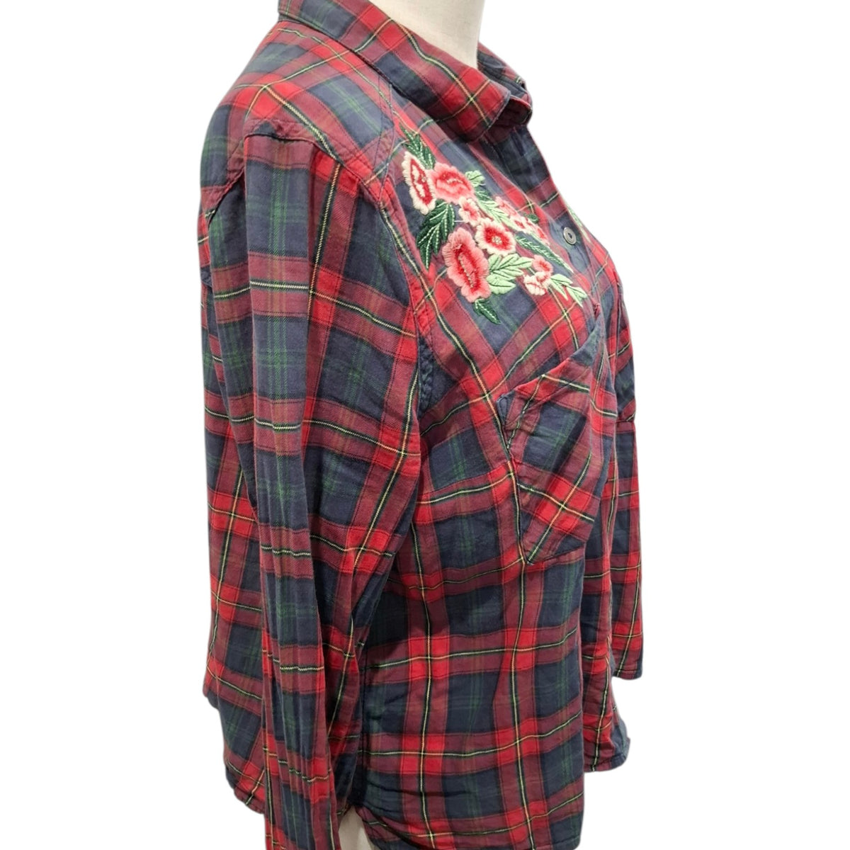 A red and navy plaid button-up shirt with a floral embroidered design on the chest, displayed on a mannequin torso against a white background.