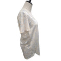 A short-sleeve V-neck top with a light beige and blue abstract pattern, displayed on a cream-colored dress form mannequin against a white background.