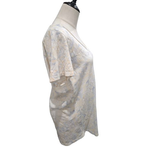 A short-sleeve V-neck top with a light beige and blue abstract pattern, displayed on a cream-colored dress form mannequin against a white background.