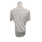 A short-sleeve t-shirt with a distressed, faded abstract pattern in beige, gray, and off-white, displayed on a mannequin torso against a plain white background.