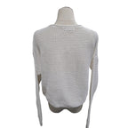 A cream-colored open-knit long-sleeve sweater displayed on a mannequin torso against a plain white background.