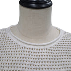 Close-up of a cream-colored open-knit sweater displayed on a beige fabric mannequin torso against a white background.