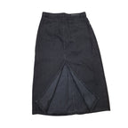 A dark charcoal gray denim midi skirt with a unique V-shaped split seam at the front hem, photographed flat against a solid white background.