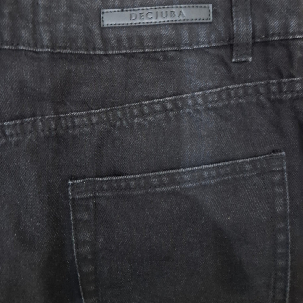 Close-up of the back waistband and pocket of dark gray denim jeans, showing a rectangular brand patch that reads DECIUBA.