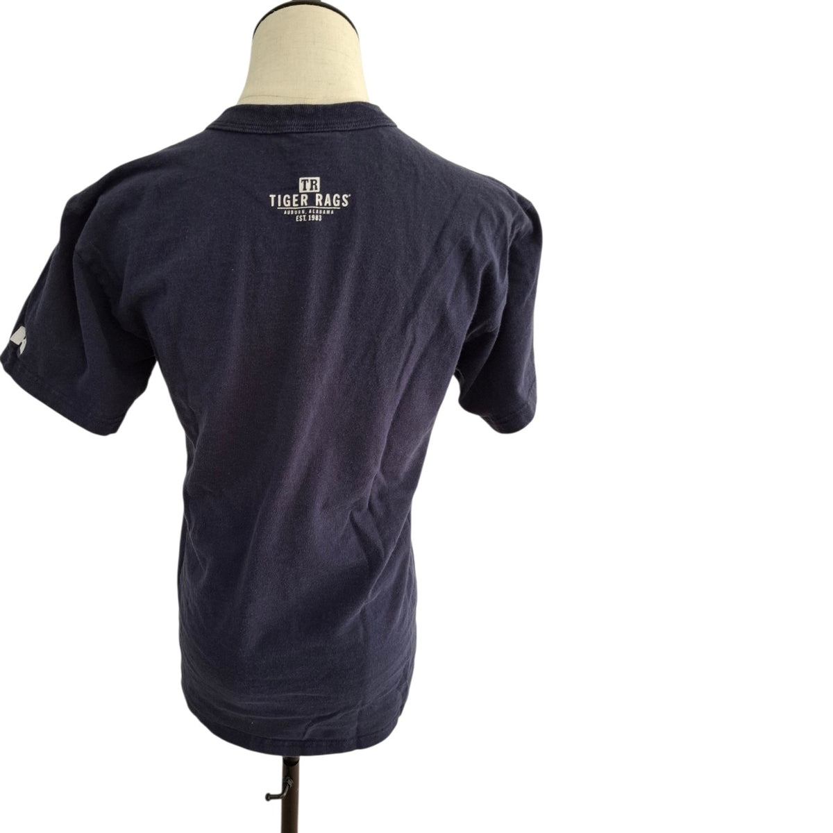 A navy blue short-sleeve t-shirt displayed on a mannequin torso, showing the back view with a white 'Tiger Bags' logo printed on the upper back.