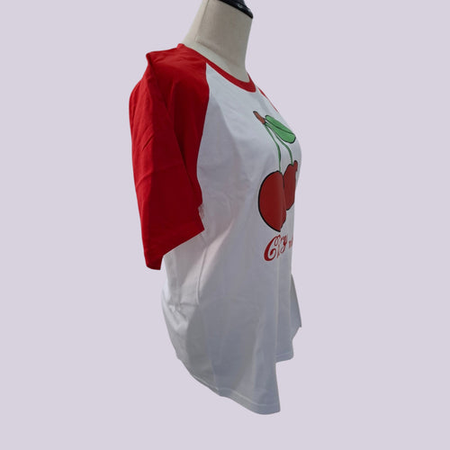 A raglan-style baseball t-shirt displayed on a mannequin torso. The shirt features red sleeves and a white body with a graphic of two red cherries with green stems and the text 'Cherry 63' printed on the front.