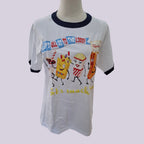 A white ringer t-shirt with dark navy blue collar and sleeve trim, featuring a colorful cartoon graphic of snack characters and the text 'LET'S ALL GO TO THE LOBBY' and 'Let's snack!'.