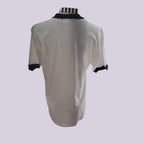 A short-sleeve white t-shirt with black trim on the collar and cuffs, displayed on a mannequin torso against a light lavender background.