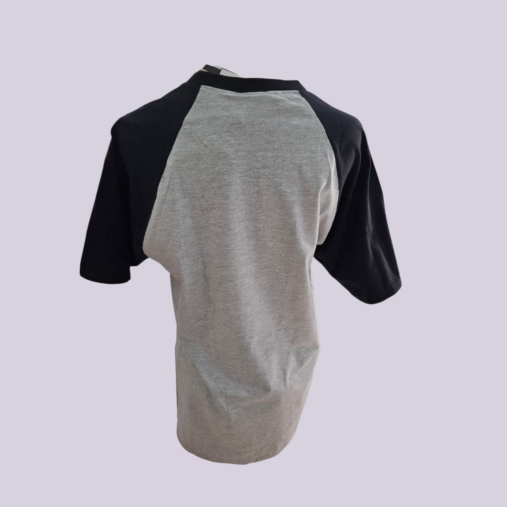 A short-sleeve raglan baseball t-shirt shown from the back, featuring a heather gray body and black sleeves, set against a solid light lavender background.