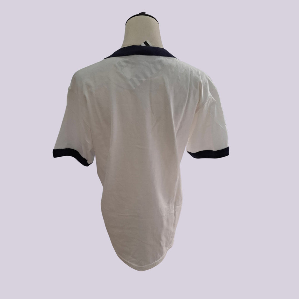 A short-sleeve ringer t-shirt shown from the back on a mannequin torso. The shirt is off-white with a dark navy blue collar and sleeve cuffs.