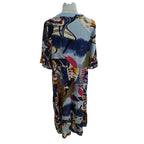 A short-sleeve kaftan dress with a vibrant, multicolor abstract print featuring blue, beige, brown, and pink elements, displayed on a white mannequin torso against a white background.