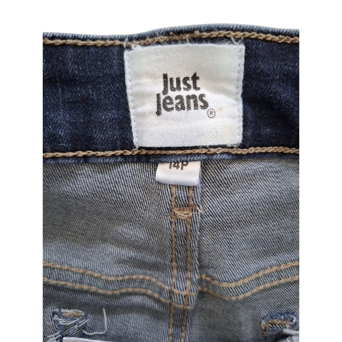 Close-up of the waistband and inner front of a pair of jeans showing the 'Just jeans' brand label and size '14p'.