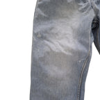 Close-up of a light blue denim garment, showing the fabric texture, fading, and a seam on a plain white background.