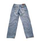 Light wash blue denim jeans shown from the back, featuring a classic five-pocket design and a brown leather patch at the back waistband, laid flat on a white background.