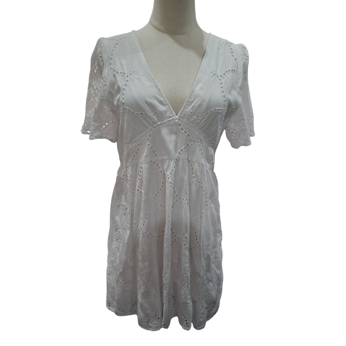 A white short-sleeve eyelet lace dress displayed on a mannequin torso against a plain white background.