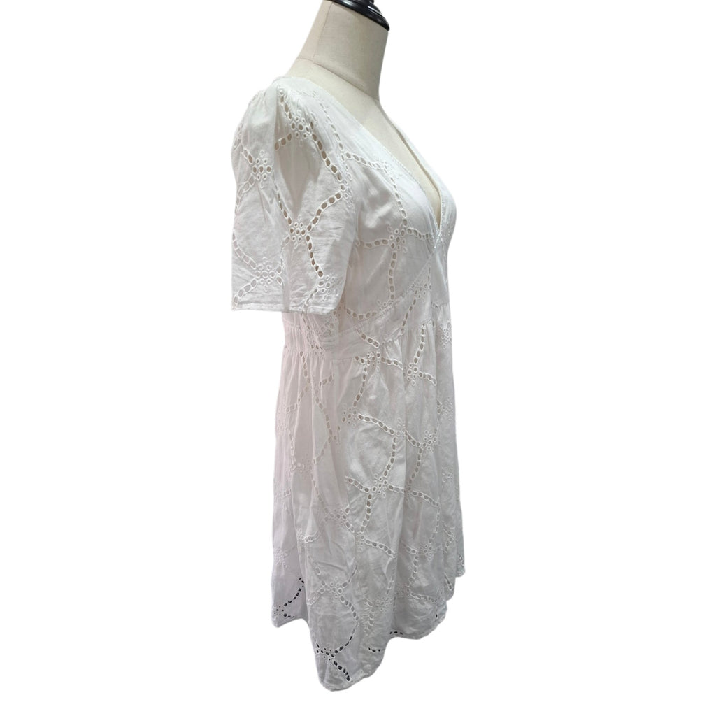 White short-sleeve eyelet lace top displayed on a cream dress form mannequin against a plain white background.