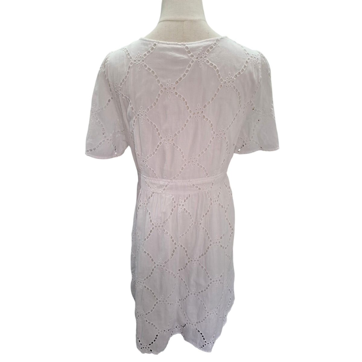 White short-sleeve eyelet lace dress displayed on a mannequin torso against a plain white background.
