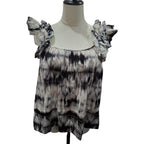 A women's sleeveless top with ruffled shoulder straps, displayed on a cream-colored dress form mannequin. The top features a black, gray, and beige tie-dye pattern.