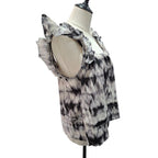 A sleeveless ruffled blouse with a black and white tie-dye pattern, displayed on a cream-colored dress form mannequin against a white background.