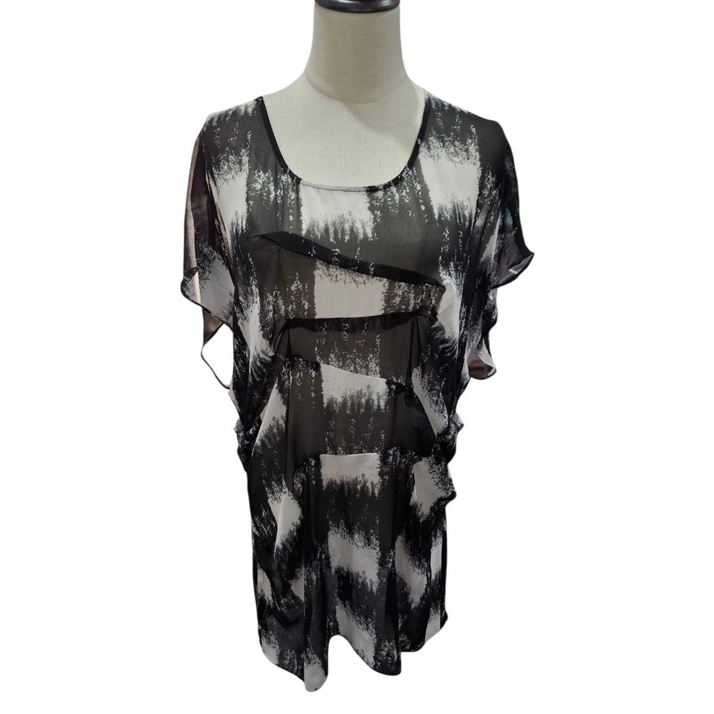 A sheer black and white abstract-patterned blouse displayed on a mannequin torso against a plain white background.