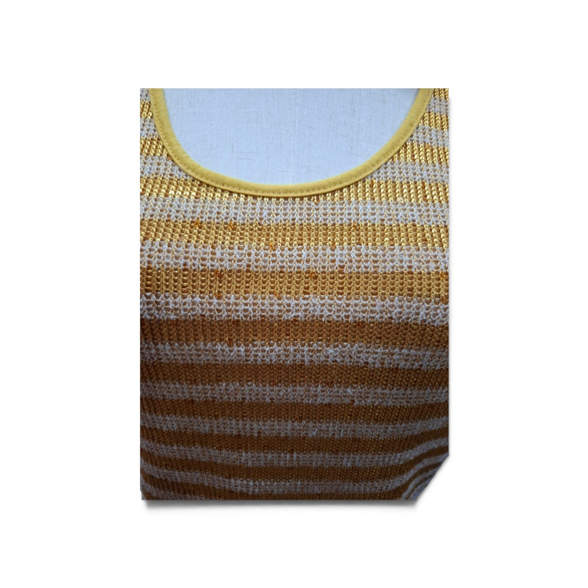 A close-up of a striped knit top on a dress form, featuring horizontal stripes of golden yellow and white, with a solid yellow ribbed neckline.