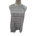 A sleeveless white top with a black grid pattern, displayed on a mannequin torso against a plain white background.