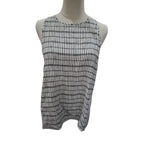 A sleeveless white top with a black grid pattern, displayed on a mannequin torso against a plain white background.
