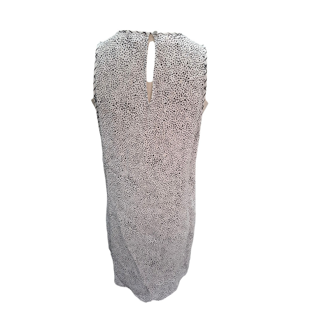 A sleeveless knit dress with an allover leopard print pattern in black and white, featuring a keyhole back neckline with tie details.