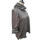 A black and white houndstooth patterned long-sleeve top displayed on a mannequin torso against a plain white background.