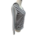 A women's long-sleeve hooded top displayed on a mannequin torso against a plain white background. The garment has a black and white striped body with a solid light gray hood and sleeves, and small red and blue embroidered accents near the placket.