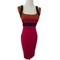 A sleeveless bodycon dress displayed on a white mannequin torso against a plain white background. The dress features a color-blocked design with a rust-orange upper section, a black band across the chest, and a deep magenta lower section.